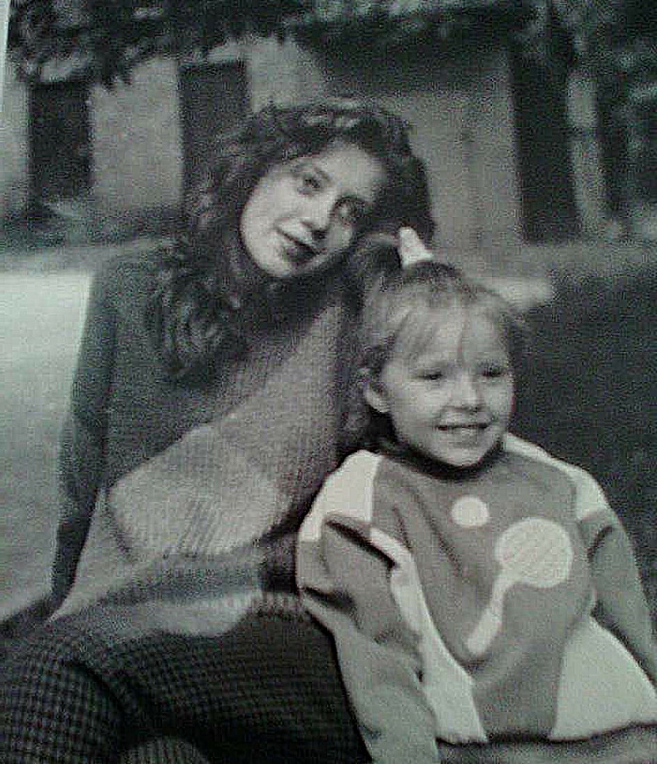 Ellie as a teenager with her little sister Anastasia, who is wearing a handmade sweater with a tennis bat and ball