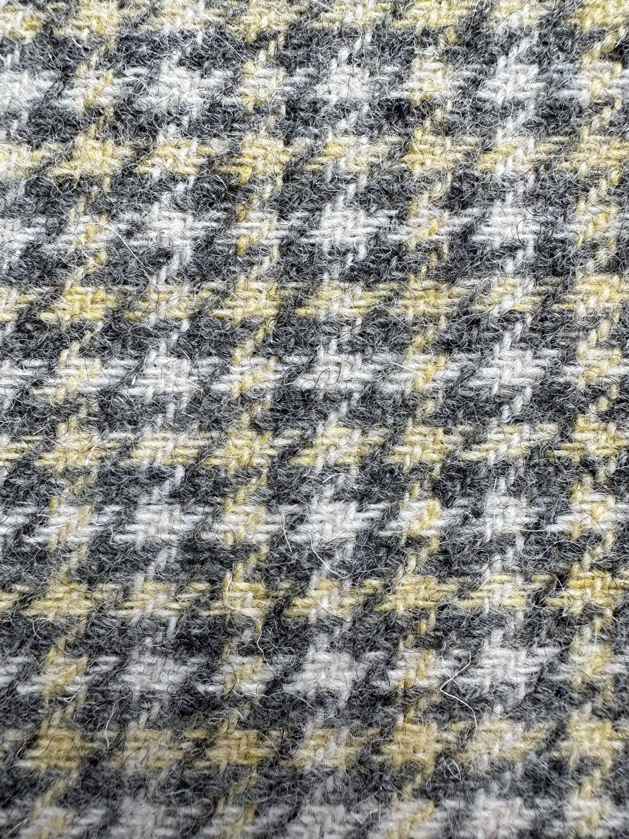 A detailed view of a tight, uniform weave in a checkered tweed fabric